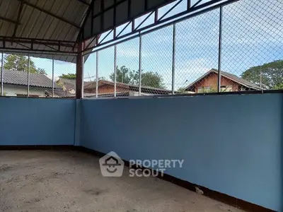 Spacious covered outdoor area with high ceiling and open view.