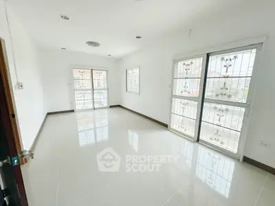 Spacious and bright room with large windows and tiled flooring, perfect for customization.