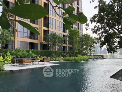 Luxurious apartment building with stunning pool and lush greenery, offering a serene urban oasis.
