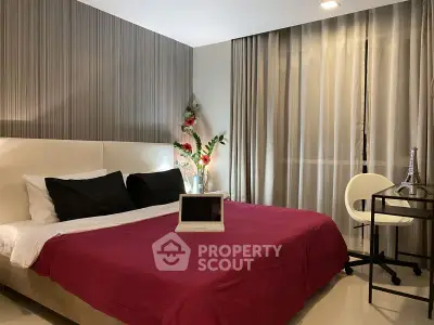 Modern bedroom with stylish decor and workspace, featuring a cozy bed and elegant lighting.