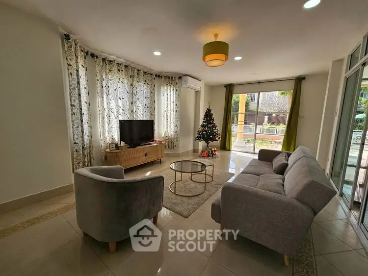 Spacious living room with modern decor and garden view, perfect for family gatherings.