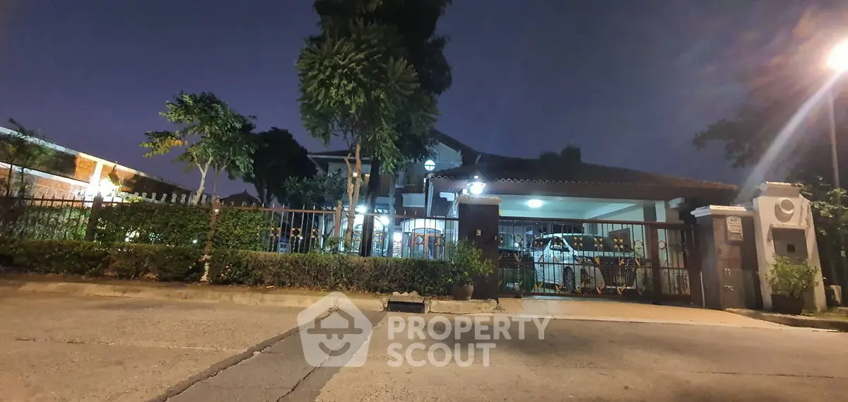 Charming suburban home with lush greenery and secure gated entrance, perfect for family living.