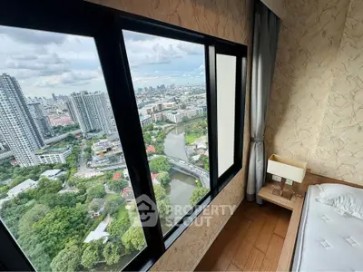 Stunning high-rise bedroom with panoramic city view and large windows.