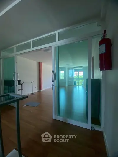 Spacious interior with glass sliding doors and wooden flooring, ideal for modern living.