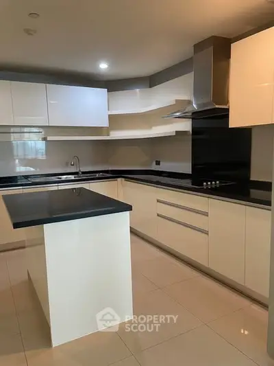 Modern kitchen with sleek white cabinets and black countertops