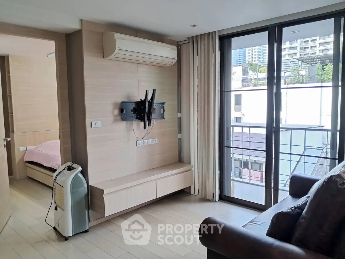 Modern living room with large windows and city view, featuring sleek air conditioning and stylish decor.