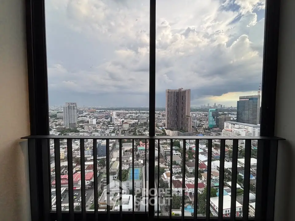Stunning cityscape view from a high-rise balcony with expansive skyline and dramatic clouds.