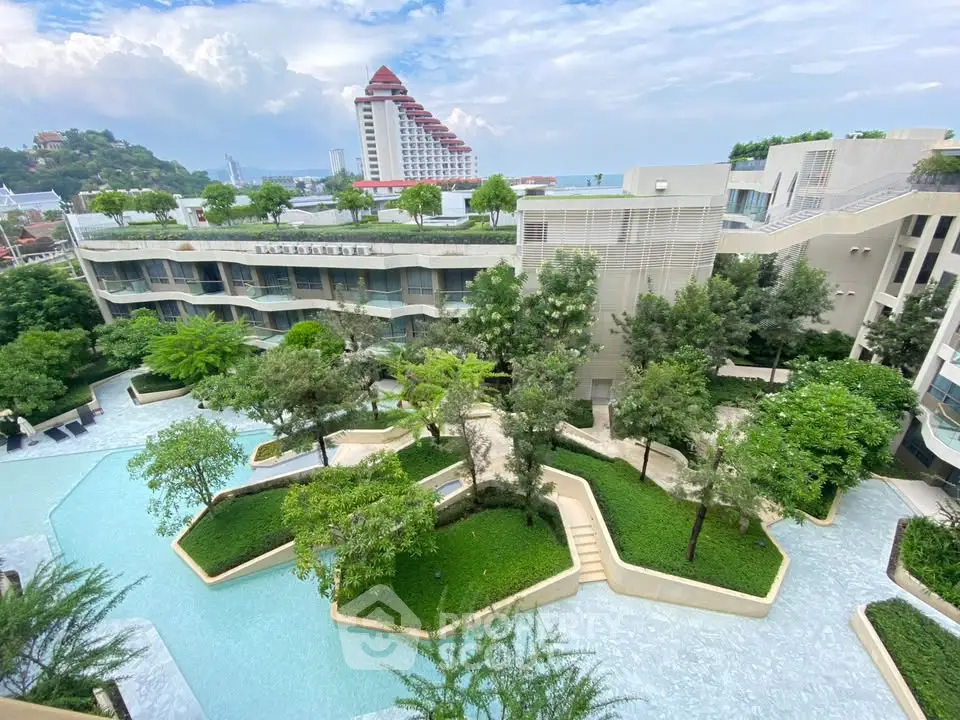 Luxurious resort-style building with lush gardens and stunning pool view.