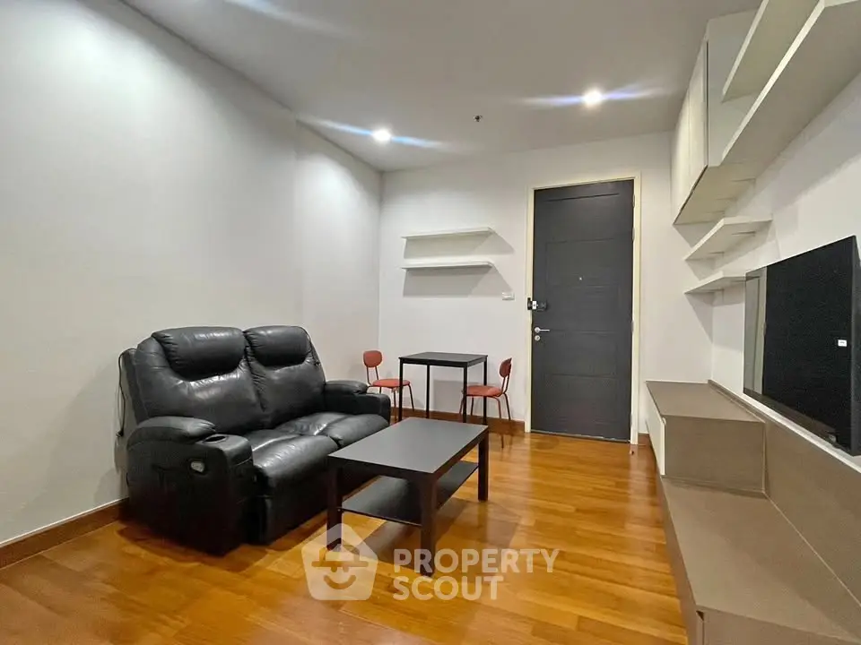 Modern living room with sleek furniture and wooden flooring, perfect for cozy gatherings.