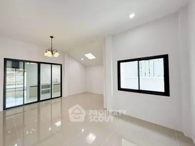 Spacious modern living area with large windows and sleek tile flooring