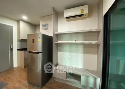 Modern apartment interior with sleek kitchen and stainless steel fridge, featuring built-in shelves and air conditioning.