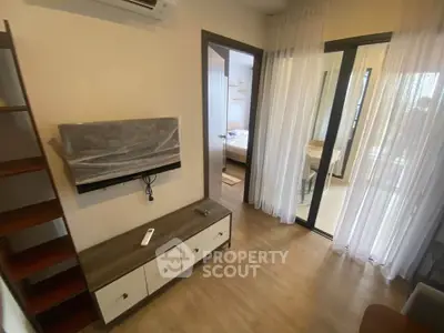 Modern apartment interior with wooden flooring and sleek furniture, featuring a cozy bedroom view.