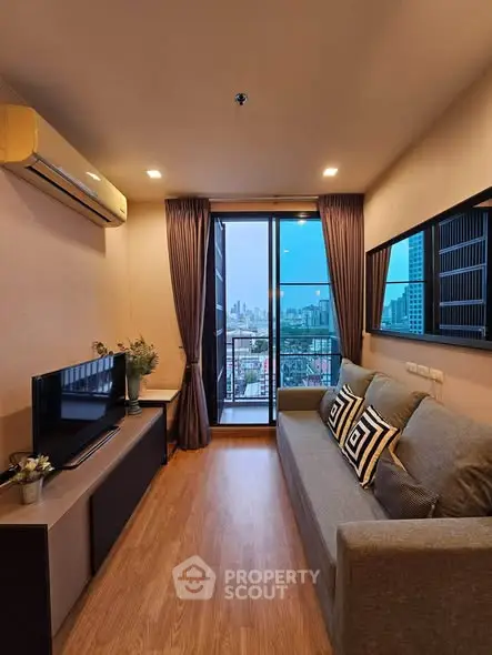 Modern living room with city view, featuring sleek furniture and large windows for natural light.