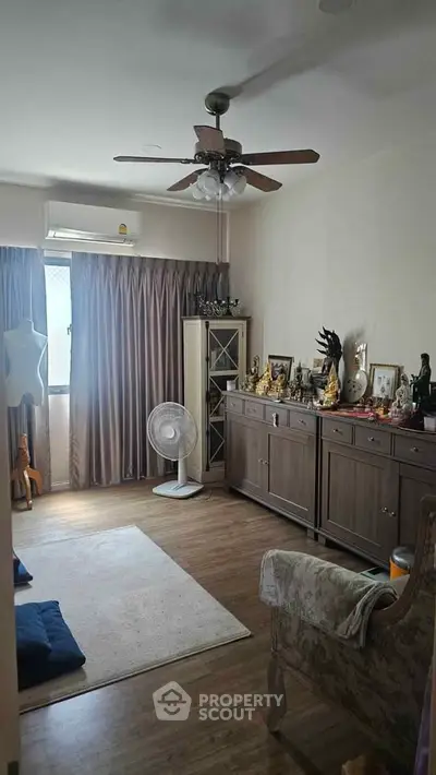 Cozy living room with wooden flooring, ceiling fan, and elegant furniture, perfect for relaxation.