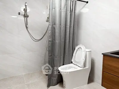 Modern bathroom with sleek shower and toilet design, featuring elegant tile work.