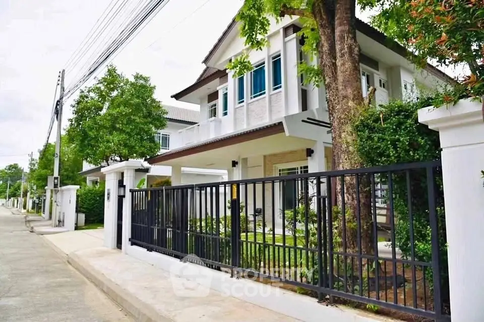 Charming two-story house with lush greenery and modern design in a serene neighborhood.