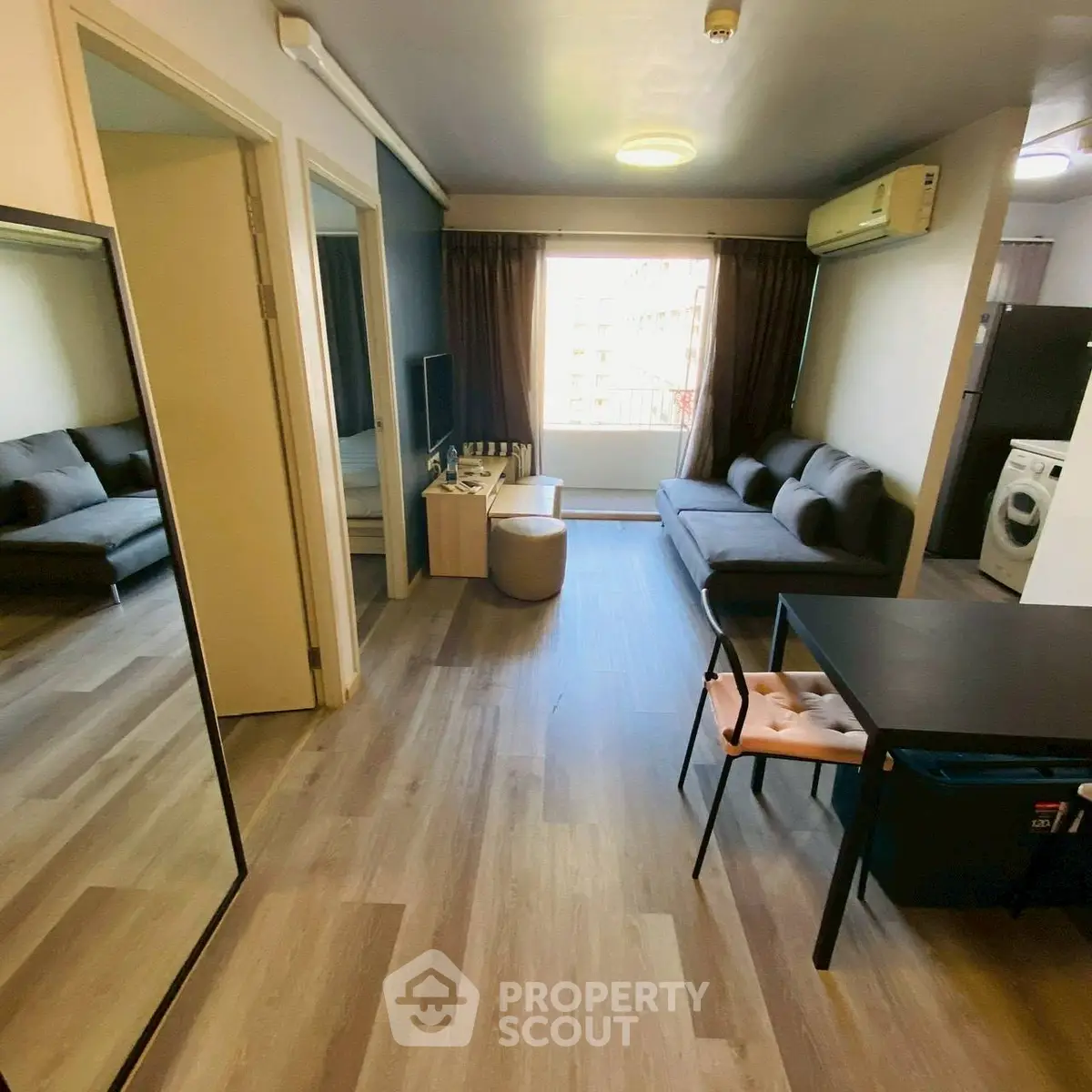 Modern living room with stylish furniture and open layout, featuring a washing machine in the corner.