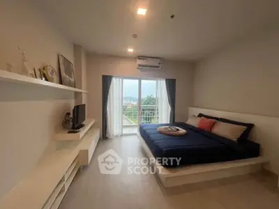 Spacious bedroom with modern decor and balcony view in a stylish apartment.