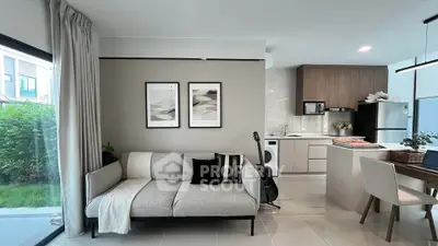 Modern open-plan living room and kitchen with stylish decor and natural light.