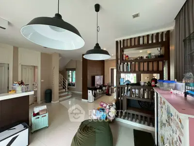 Spacious living room with modern lighting and open layout, ideal for family gatherings.