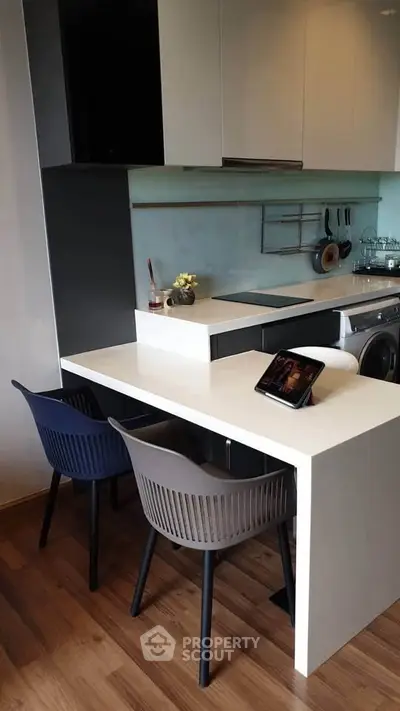 Modern kitchen with sleek design, featuring a compact dining area and integrated appliances.