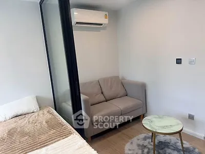 Cozy bedroom with modern air conditioning and stylish sofa