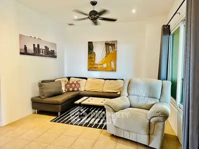 Cozy living room with sectional sofa and recliner, modern decor and ceiling fan.