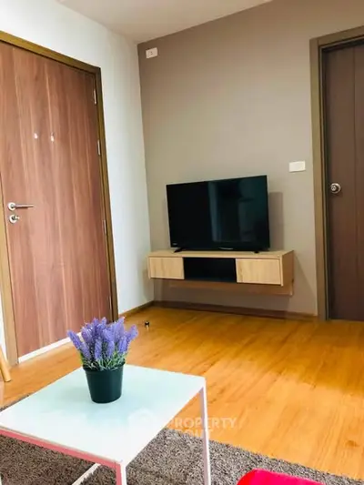 Modern living room with wooden flooring and sleek TV setup