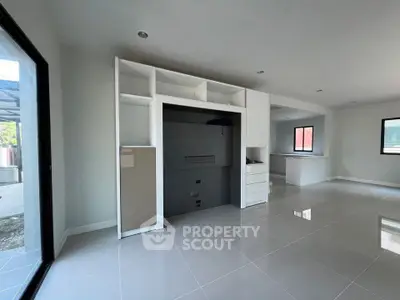 Spacious modern living area with sleek built-in storage and large windows