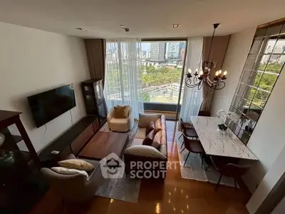Luxurious living room with city view, elegant chandelier, and modern furnishings in high-rise apartment.