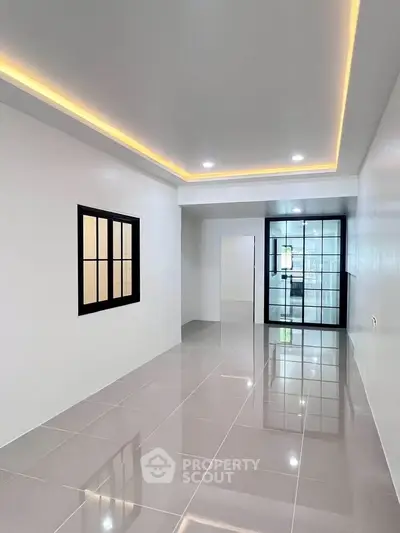 Modern minimalist living room with sleek tile flooring and recessed lighting