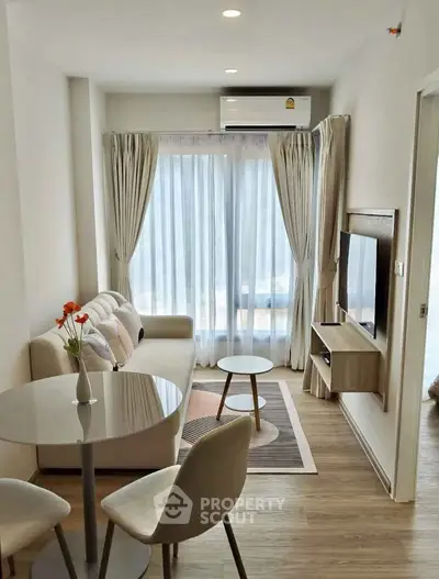Modern living room with cozy seating and natural light in a stylish apartment.