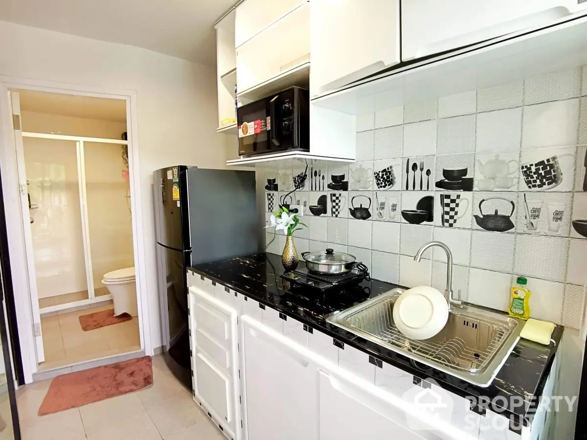 Bright and inviting kitchen with modern appliances, ample counter space, and chic black and white tile backsplash, perfect for culinary enthusiasts.