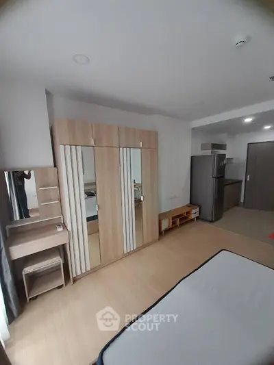 Modern bedroom with wardrobe and kitchenette in stylish apartment