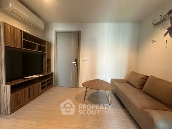 Modern living room with sleek furniture and wall-mounted air conditioner.