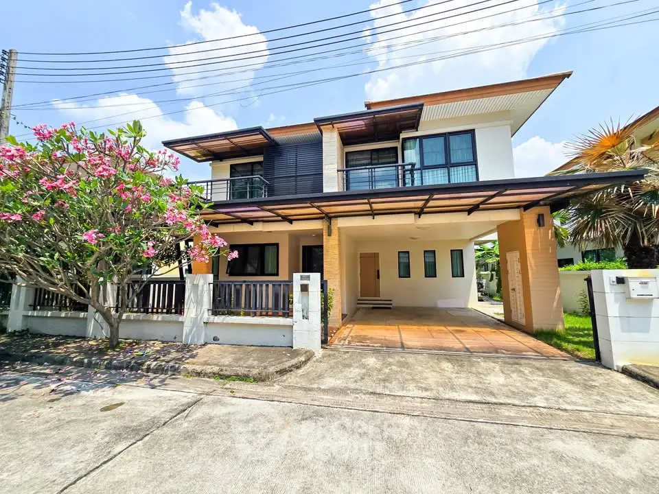 Stunning modern two-story house with spacious balcony and lush garden view.