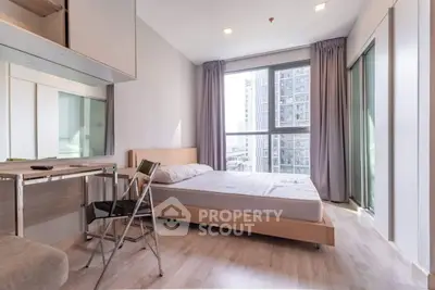 Modern bedroom with large window and city view, featuring minimalist furniture and natural light.