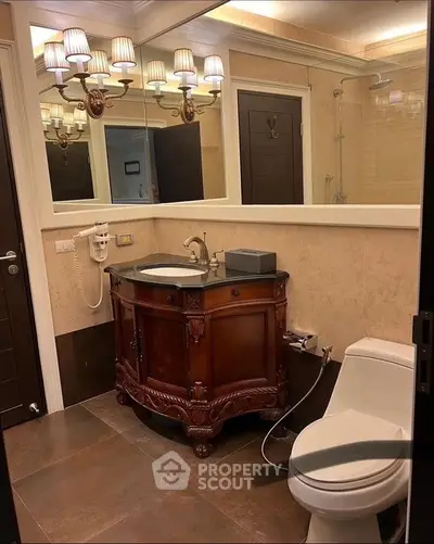 Elegant bathroom with vintage wooden vanity and modern fixtures in a luxurious home.