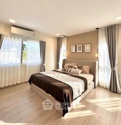 Spacious and sunlit bedroom with modern decor and large windows