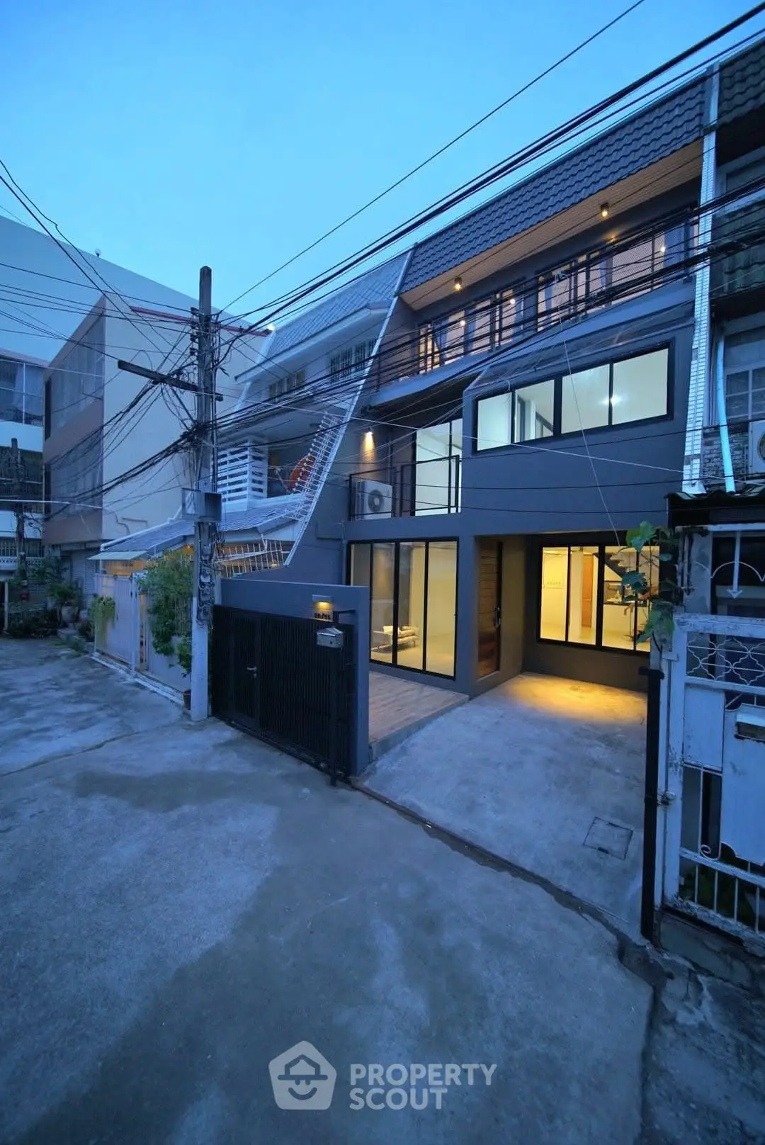Modern townhouse exterior with sleek design and large windows at dusk.