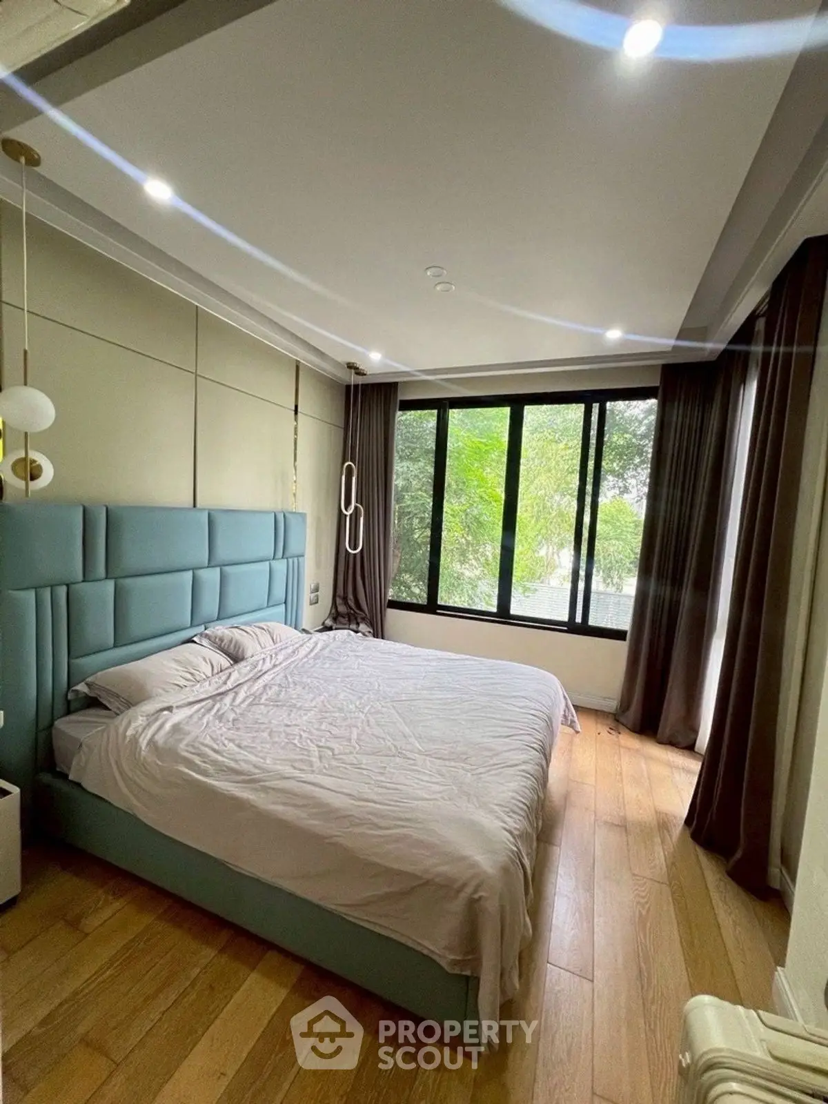 Spacious bedroom with large window and modern decor