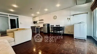Spacious living room with modern kitchen and appliances in open layout apartment.