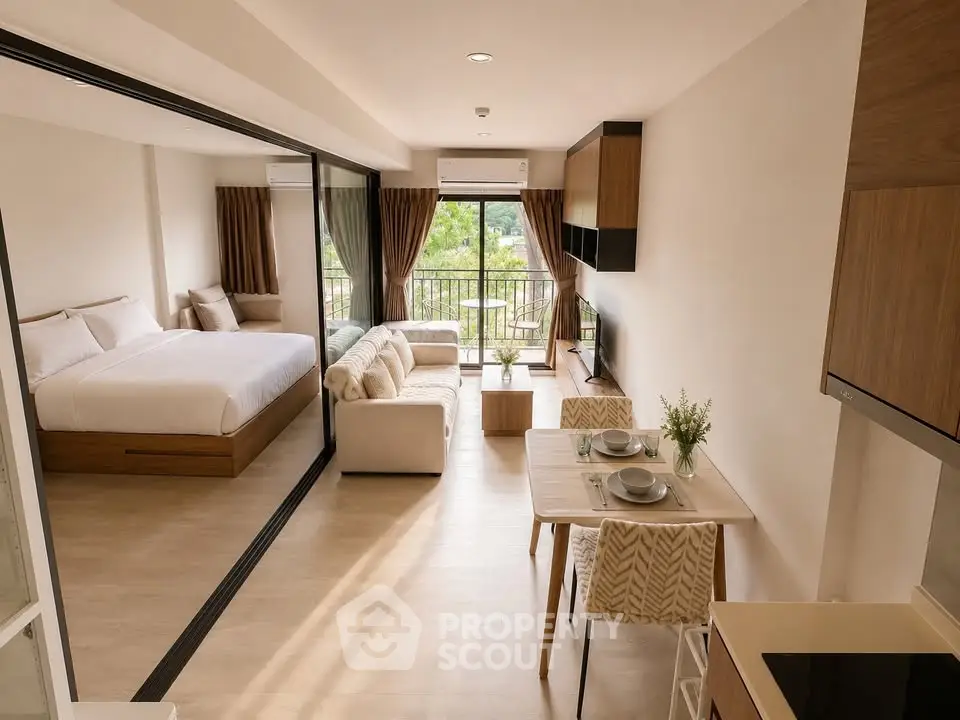 Modern open-plan studio apartment with cozy living area and balcony view
