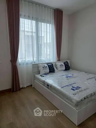 Cozy bedroom with modern decor and large window for natural light