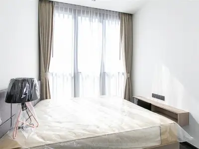Bright modern bedroom with large windows and minimalist decor.
