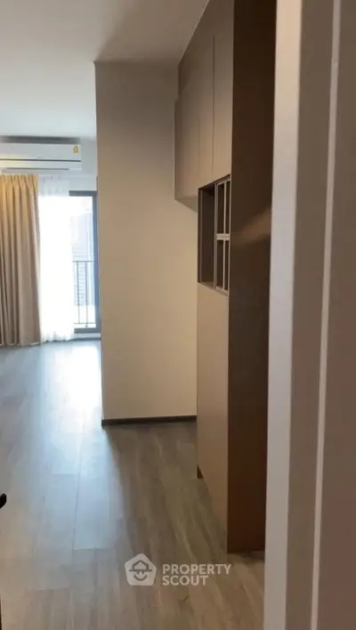 Modern apartment interior with wooden flooring and large window