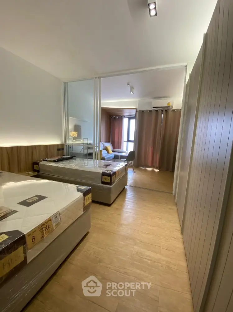 Spacious bedroom with twin beds and modern decor, featuring large windows for natural light.