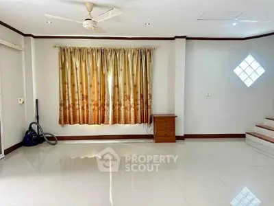 Spacious living room with glossy tiled floors and elegant curtains