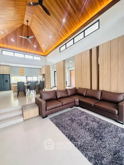 Luxurious open-plan living room with high wooden ceiling and modern furnishings