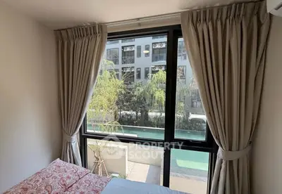 Cozy bedroom with large window overlooking pool and modern building